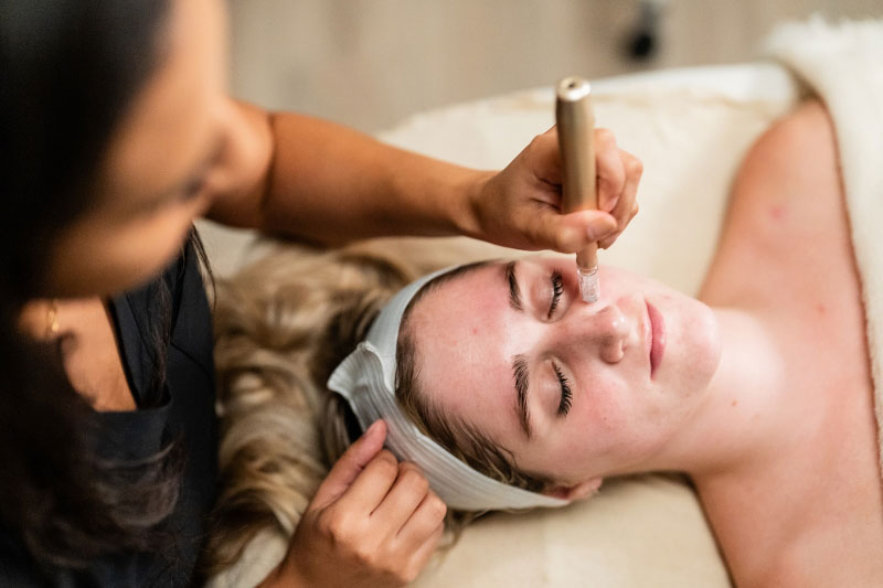 A woman receives a hydrabrasion treatment in a facial spa near Northwest Dallas, TX.