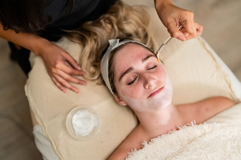A woman receives an acne facial at a facial spa near Dallas, TX.
