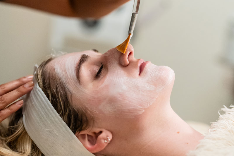 A female client enjoys a facial with a medium peel at a skincare spa in Flower Mound, TX.